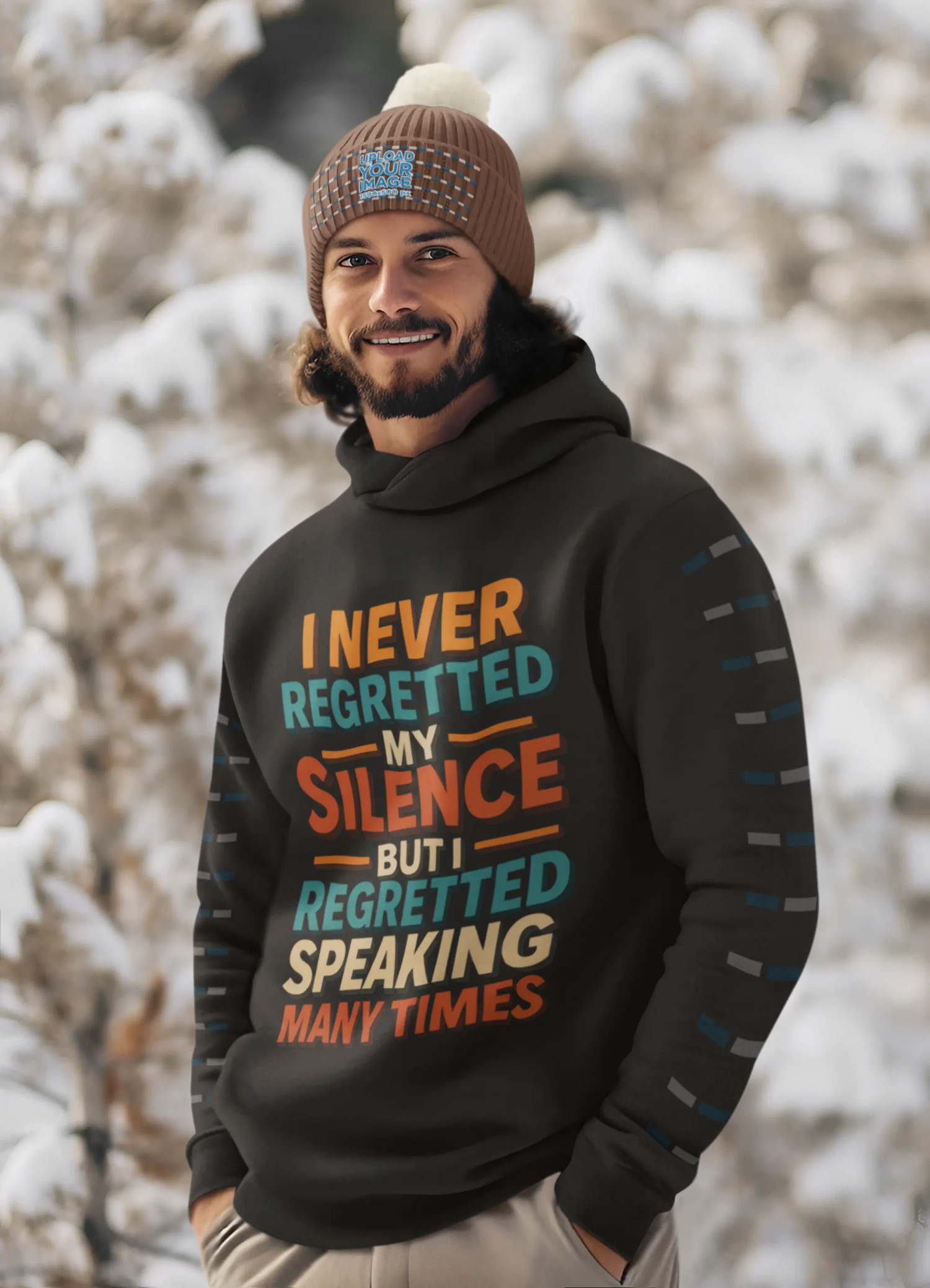 Black men's hoodies with a colorful motivational quote graphic that reads: "I NEVER REGRETTED MY SILENCE BUT I REGRETTED SPEAKING MANY TIMES." The man wearing the hoodie is outdoors in a snowy landscape.